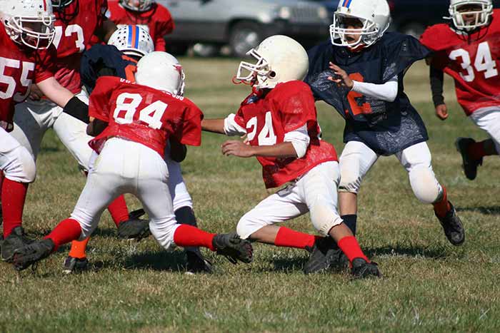 Kids in red jerseys playing football